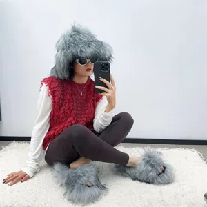 Detailed shot of grey faux fox fur slippers and matching oversized furry hat on a model