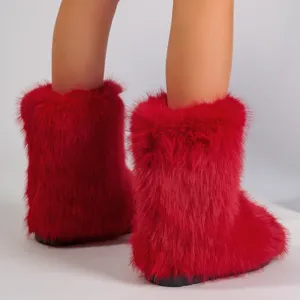 Vue détaillée de bottes de neige rouges en fausse fourrure à texture moelleuse et semelle noire