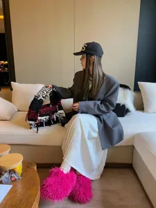 Hot pink Mongolian sheep fur slides boots styled with a casual chic outfit in a living room