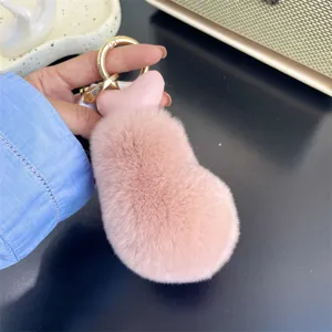 Detail view of the soft pink rex rabbit fur chicken drumstick keychain with gold clasp