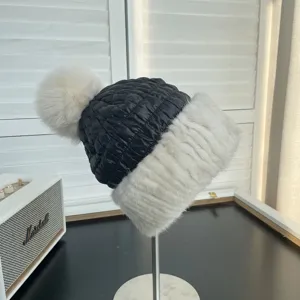 Detail of women's quilted down hat with white mink fur brim and fluffy fox fur pom pom