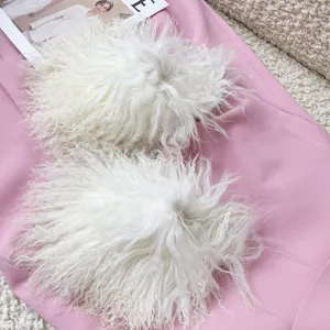 Detailed view of fluffy white Mongolian sheep fur slides with curly texture on pink fabric