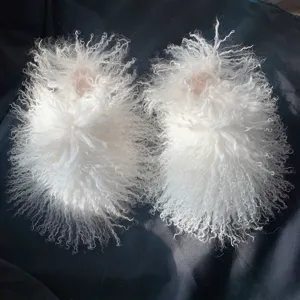 Close-up of luxurious white Mongolian sheep fur slippers with soft curly long-hair texture