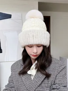 Elegant white mink fur knitted winter hat featuring a fluffy fox fur pom-pom for women