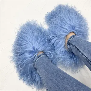Close-up of fluffy light blue Mongolian sheep fur slides worn with blue denim jeans