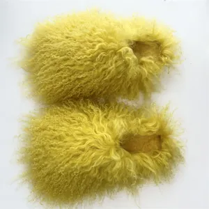 Overhead view of plush yellow Mongolian lamb fur slippers with soft curly texture