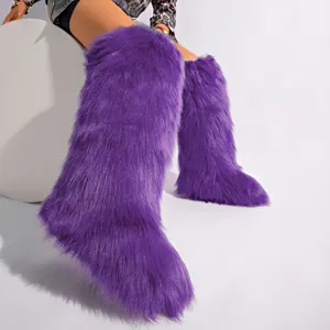 Gros plan de bottes hautes en fausse fourrure violette portées par un mannequin en studio.