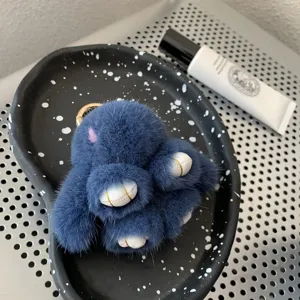 Macro view of blue mink fur bunny keychain with plush texture and golden metal ring