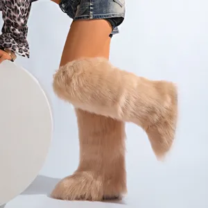 Gros plan de bottes d'hiver élégantes en fausse fourrure de renard beige pour femmes.