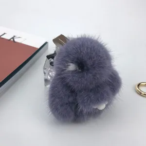 Close-up detail of a fluffy 8cm purple mink fur rabbit keychain on minimalist background.