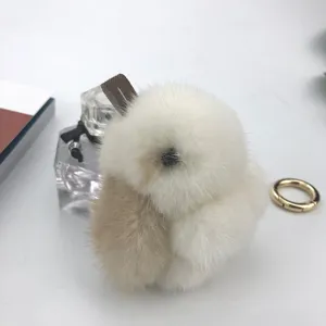 Macro detail of the fluffy mink fur rabbit charm with soft white and beige fur textures.