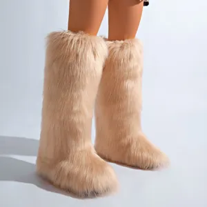 Vue détaillée de bottes de neige hautes en fausse fourrure duveteuse de couleur beige.