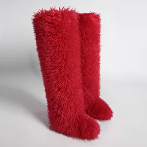 Vista lateral de las botas de invierno rojas de piel sintética por encima de la rodilla