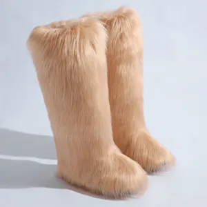 Détail rapproché de luxueuses bottes de neige en fausse fourrure de renard couleur abricot