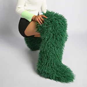 Vista macro detallada que muestra la densa textura de las botas altas de piel sintética verde.