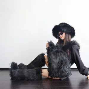 Model sitting in Y2K outfit showing a fluffy black faux fur backpack and matching boots