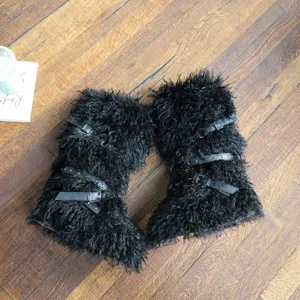 Dettaglio di stivali da neve alla moda in pelliccia nera con cinturini e borchie
