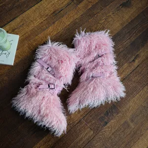 Dettaglio degli stivali da neve rosa in ecopelliccia con cinturini e fibbie.