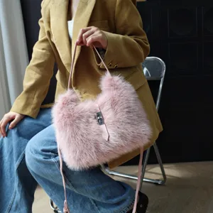 Detailansicht einer rosa Kunstfelltasche, gehalten von einem Model im gelben Blazer.