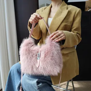 Elegante pinke flauschige Kunstfell-Umhängetasche mit silbernem Drehverschluss am Modell.
