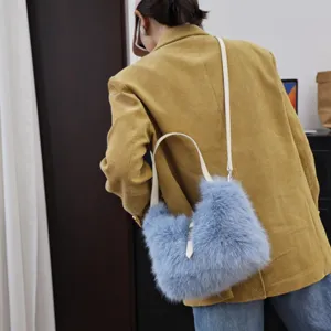 Detailansicht einer weichen blauen Kunstfell-Umhängetasche getragen mit gelbem Cord-Blazer
