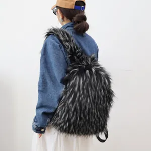 Stylish model wearing a large black and gray faux raccoon fur backpack with a denim jacket.