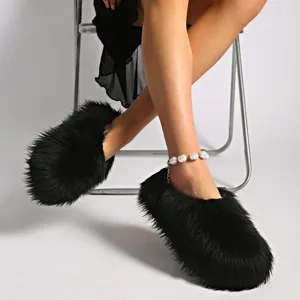 Vista de cerca de zapatillas negras de pelo sintético con tobillera de perlas elegante.