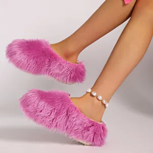 Primer plano de pantuflas rosas de piel sintética con elegante pulsera de tobillo