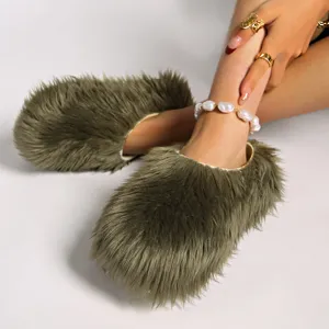 Primer plano de zapatillas de plataforma de pelo sintético verde oliva con tobillera de perlas.