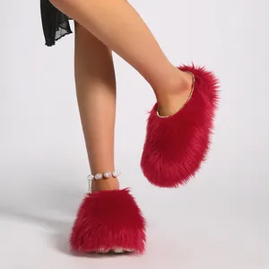 Primer plano de pantuflas rojas de pelo con plataforma y textura de piel