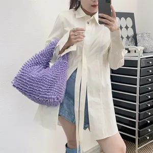 Grand sac fourre-tout en peluche lavande porté avec une chemise blanche chic