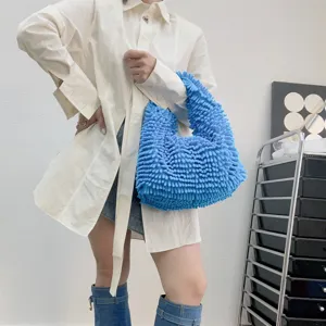 Vue détaillée d'un sac à main bleu en peluche à texture de vadrouille porté par un mannequin