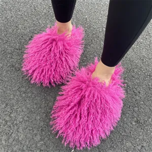 Gedetailleerd bovenaanzicht van felle roze Mongoolse imitatiebont slippers op asfalt