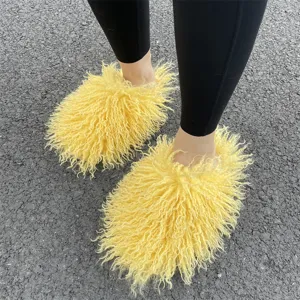 Macrodetail van gele Mongoolse imitatiebont slippers gedragen op asfalt in de buitenlucht.