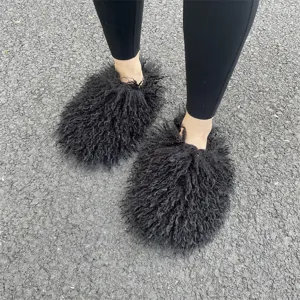 Gedetailleerd overzicht van pluizige zwarte Mongoolse bontslippers op een asfaltweg