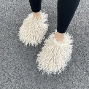Detailweergave van de pluizige crème Mongoolse imitatiebont slippers buiten gedragen op weg