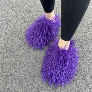 Detailopname van pluizige paarse Mongoolse imitatiebont slippers op buitenbestrating