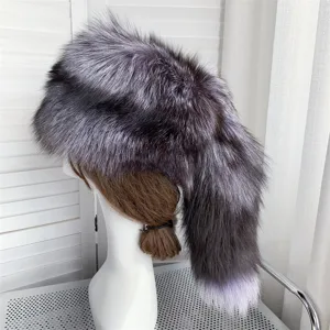 Close-up detail of a silver fox fur hat with a long decorative tail for winter warmth.
