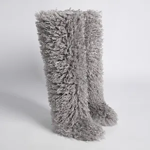 Detalle de botas de nieve por encima de la rodilla de piel sintética de cordero gris rizado