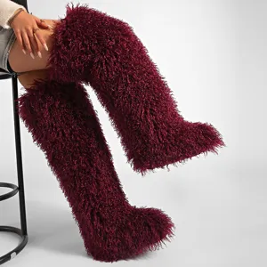 Detalle de botas altas granate de pelo sintético rizado estilo cordero tibetano
