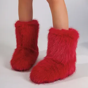 Gros plan sur la texture en fausse fourrure rouge vif des bottes de neige style Y2K
