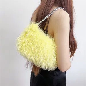 Detail view of a yellow shaggy faux fur underarm bag featuring a chunky silver chain strap