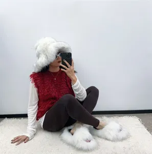 Detail view of luxury white faux raccoon fur hat and matching plush slippers set