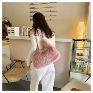 Close-up of pink faux fur plush handbag worn as a stylish crossbody bag