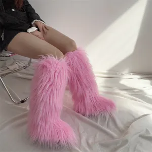 Close-up of pink furry knee-high snow boots with long faux fur texture
