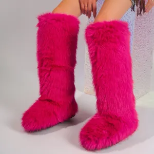 Close-up of vibrant hot pink Y2K faux fur knee-high snow boots shown on model legs.