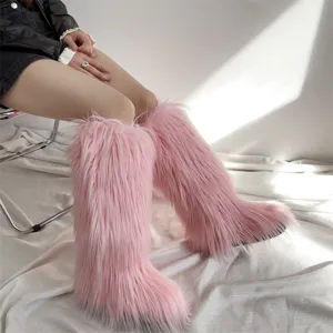 Fashionable pink faux fur knee-high snow boots for women shown worn with a casual outfit
