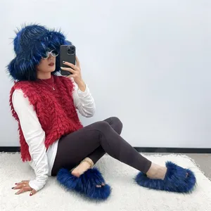 Blue faux fur hat and matching slide slippers set worn by a model in a studio setting