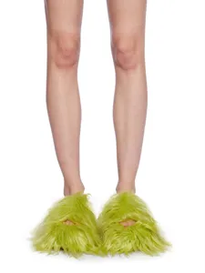 Chaussons Y2K vert néon en fausse fourrure longue présentés sur jambes vue détaillée