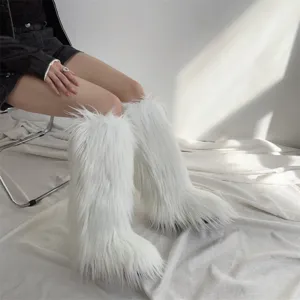 Close-up shot of stylish white long faux fur knee-high winter snow boots for women